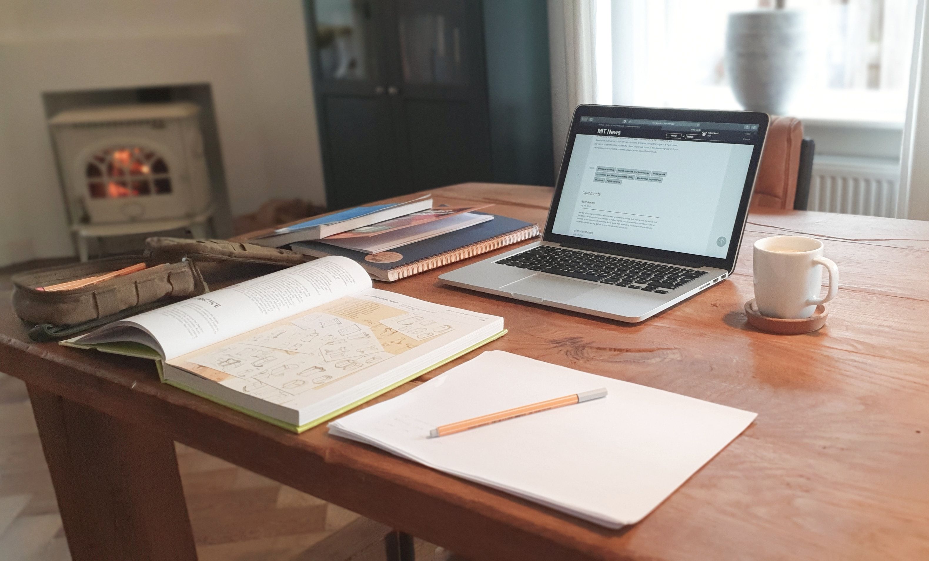 Bureau avec un livre ouvert un bloc note , un ordinateur portable et un café